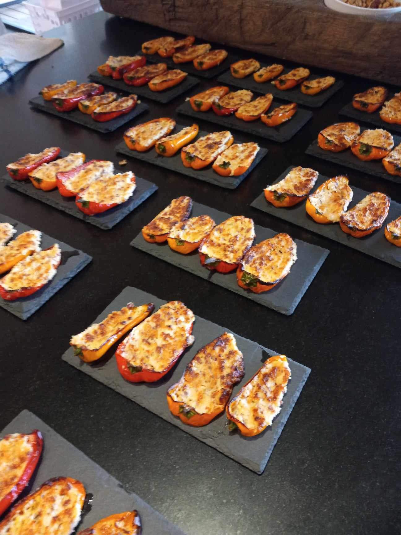 Trays of cheese-stuffed mini sweet peppers plated on slate for a party