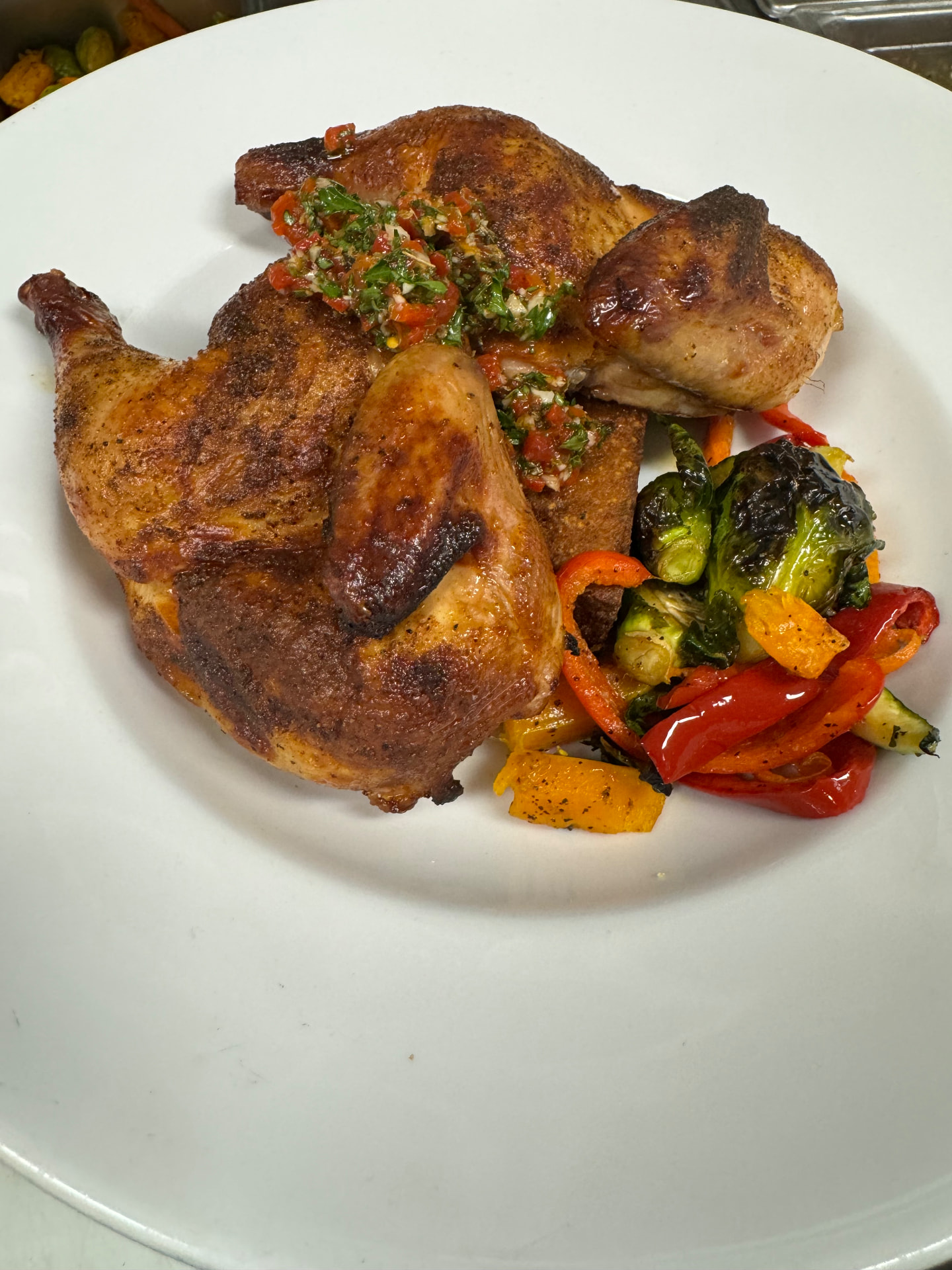 Roasted half chicken with charred peppers and brussels sprouts