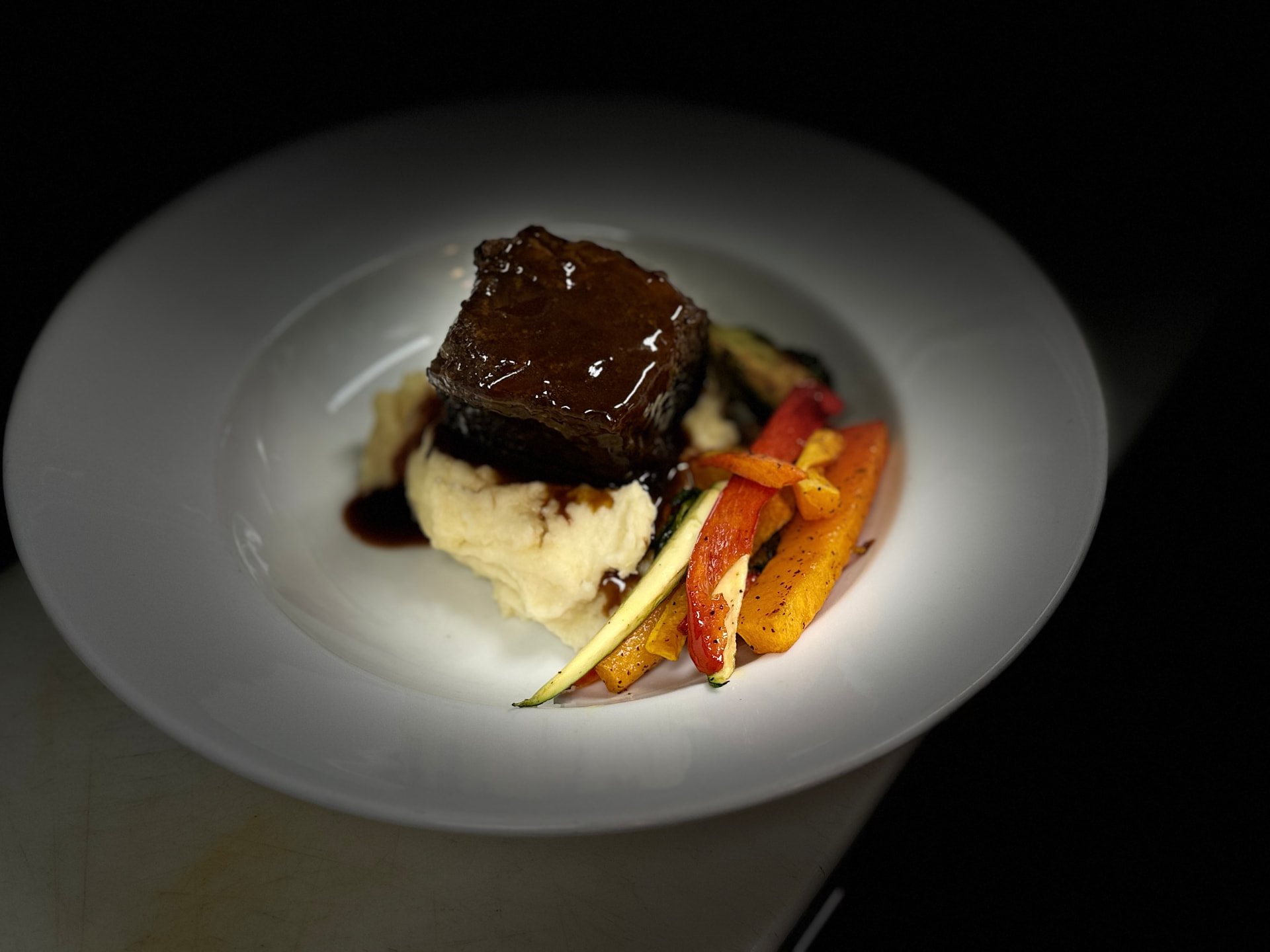 Braised short rib over whipped potatoes with roasted vegetables