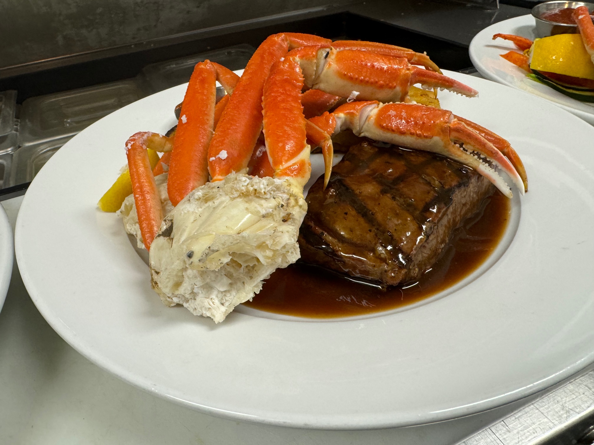 Grilled filet with demi-glace served with snow crab legs and lemon